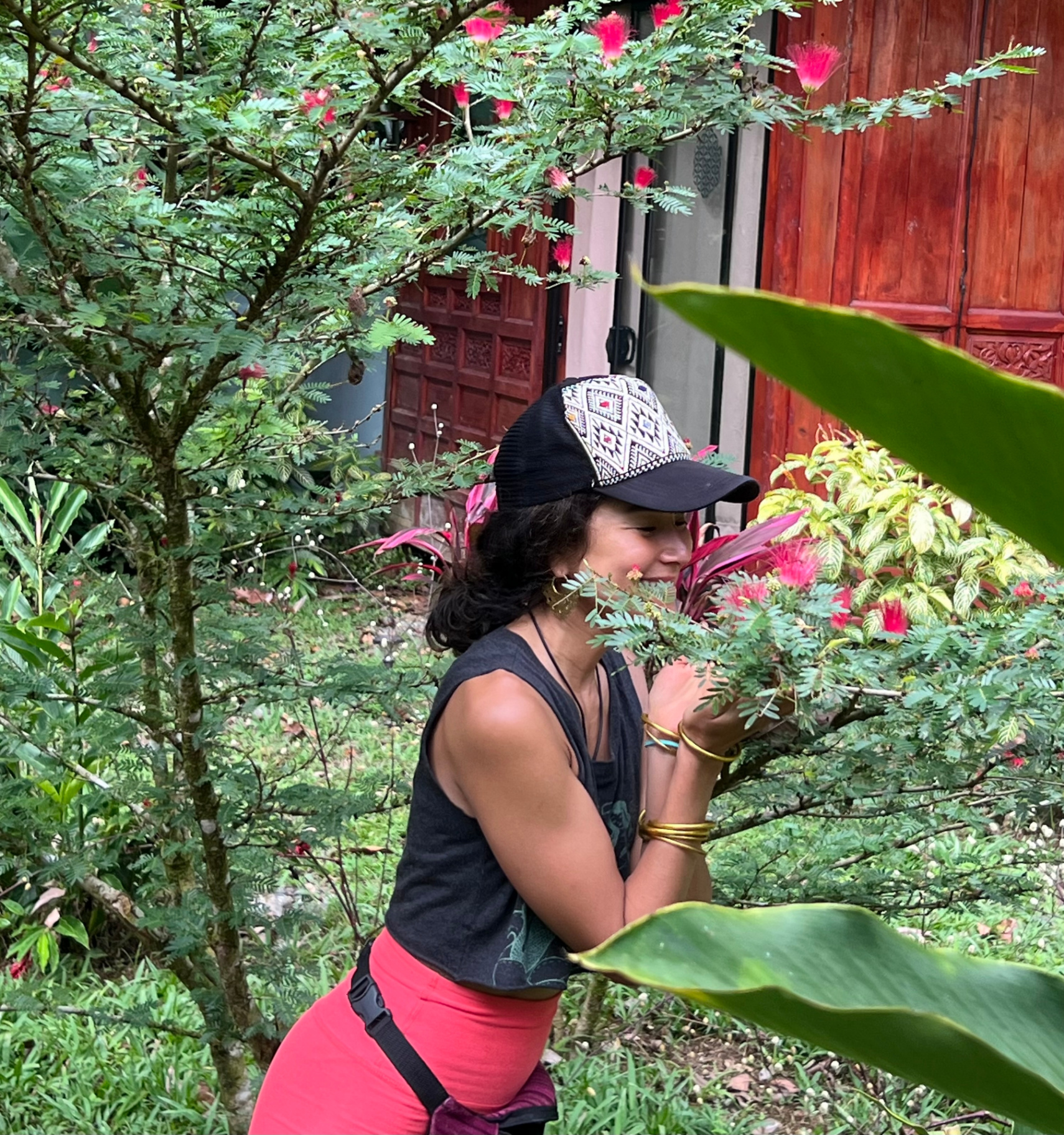 Aimi smelling Bobinsana flowers in a tropical garden